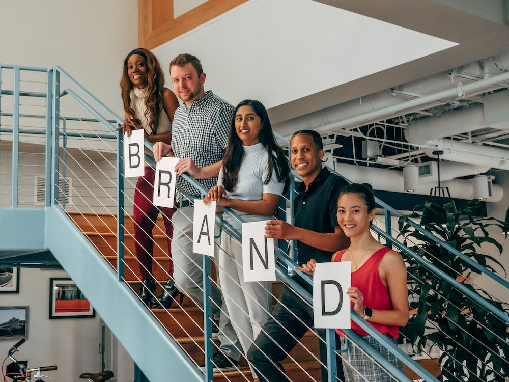a group of people holding paper with letters while standing on the stairs