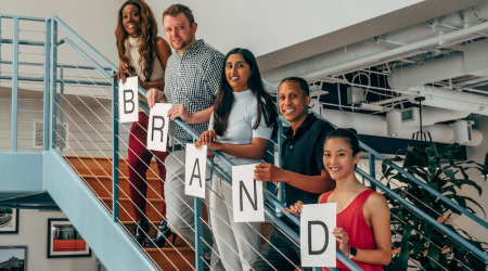 a group of people holding paper with letters while standing on the stairs